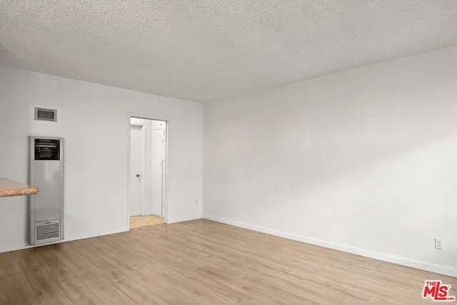 a view of an empty room and wooden floor