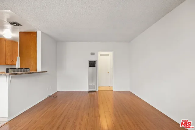 a view of a room with wooden floor and a window