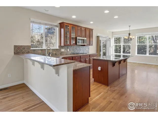 a kitchen with stainless steel appliances granite countertop a stove a sink and a granite counter tops with wooden floors