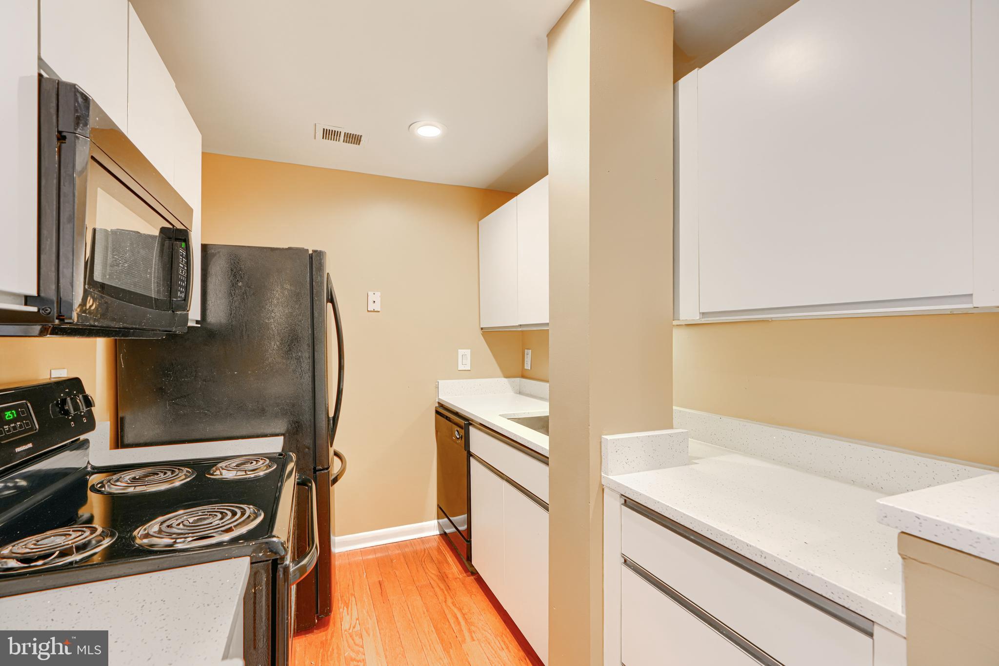 2639 Boston Street, Unit 305 Baltimore, MD 21224 - Photo 11 of 21 a kitchen with a refrigerator stove and microwave