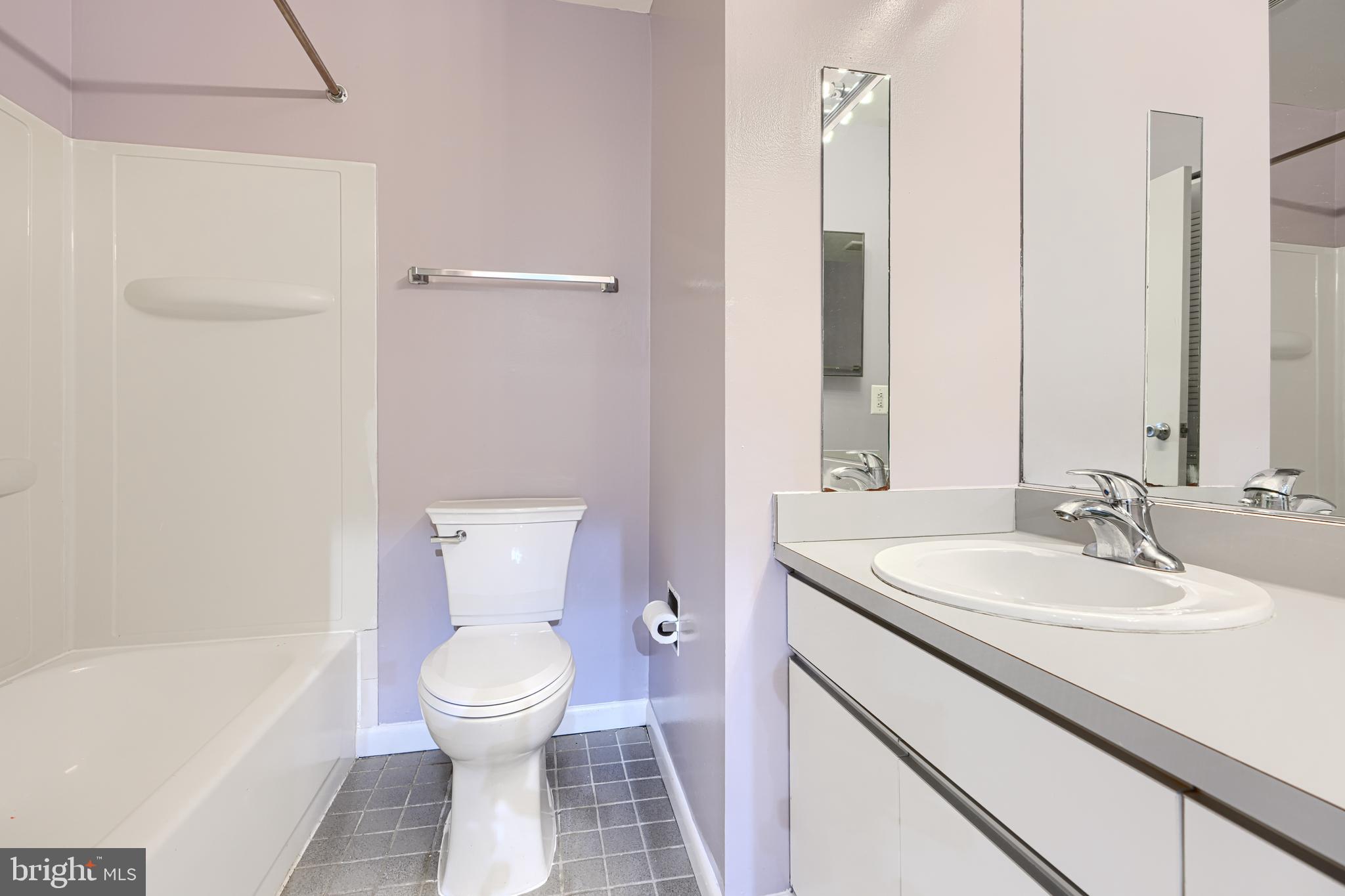 2639 Boston Street, Unit 305 Baltimore, MD 21224 - Photo 19 of 21 a bathroom with a toilet sink and mirror