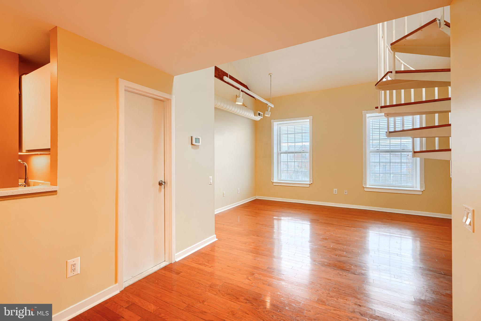 2639 Boston Street, Unit 305 Baltimore, MD 21224 - Photo 4 of 21 a view of an empty room with wooden floor and a window