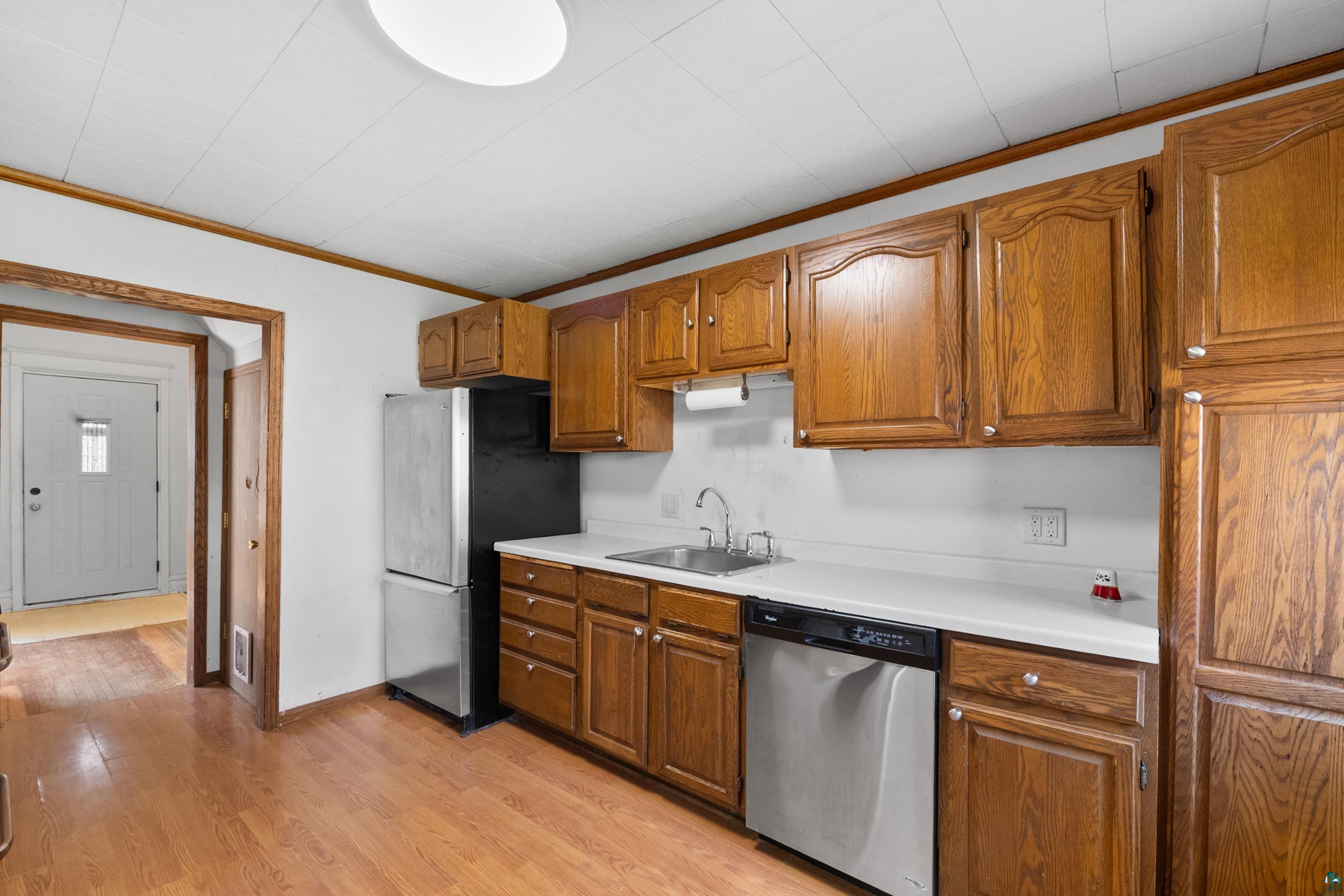 3067 Restormel Street Duluth, MN 55806 - Photo 8 of 25 Kitchen featuring wood-finish cabinetry, stainless steel dishwasher, and white countertops