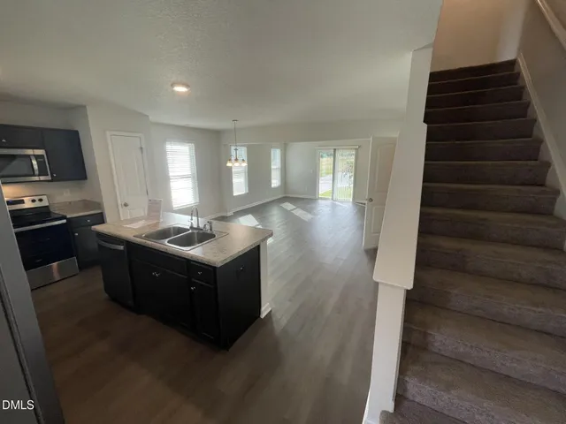 a kitchen with a stove a sink a refrigerator and a counter top space