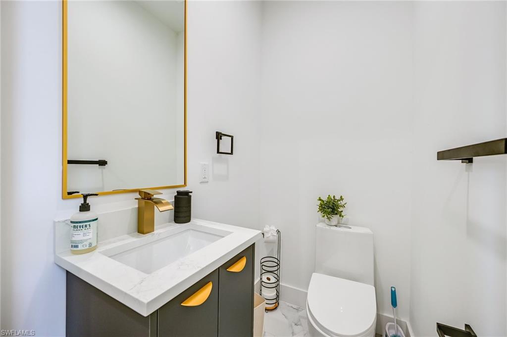 3384 Canal Street Naples, FL 34112 - Photo 13 of 34 Bathroom with vanity and light marble finish floors