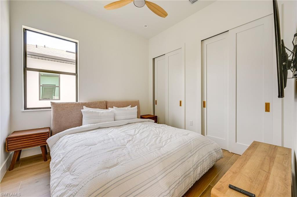 3384 Canal Street Naples, FL 34112 - Photo 26 of 34 Bedroom featuring two closets, light wood finished floors, and ceiling fan