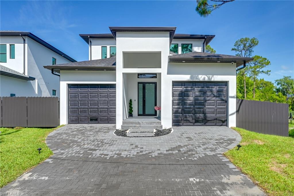 3384 Canal Street Naples, FL 34112 - Photo 34 of 34 View of front of house featuring stucco siding, decorative driveway, and a garage