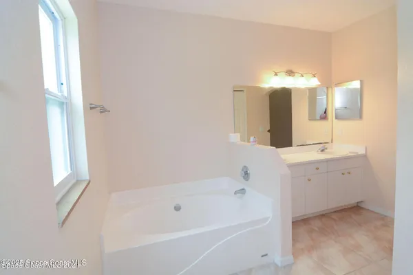 a bathroom with a tub sink and mirror