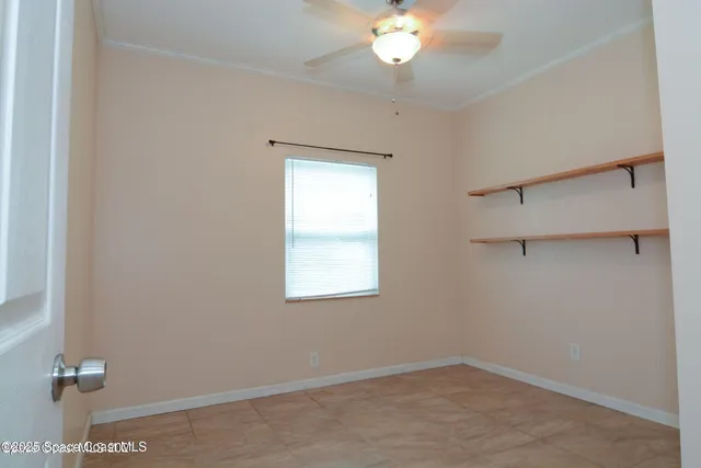 an empty room with a chandelier fan