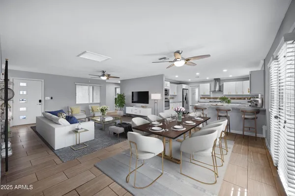 a living room with couches kitchen view and a dining table with kitchen view