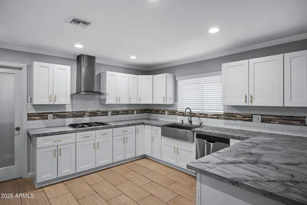 a large kitchen with a large counter top stainless steel appliances and cabinets
