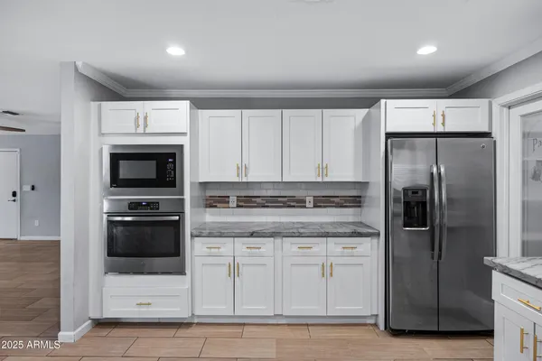 a kitchen with granite countertop a sink cabinets and stainless steel appliances
