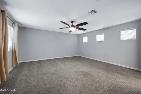 a view of an empty room with a ceiling fan
