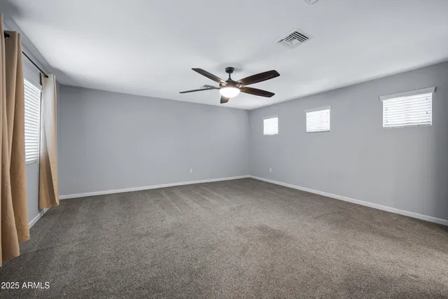 an empty room with a window and a fan