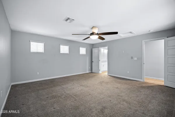 an empty room with closet and ceiling fan