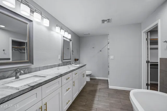 a bathroom with a granite countertop sink toilet and shower
