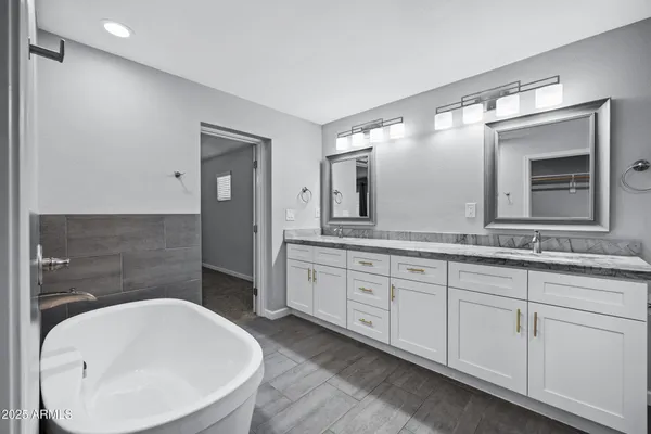 a bathroom with a granite countertop double vanity sink and a mirror