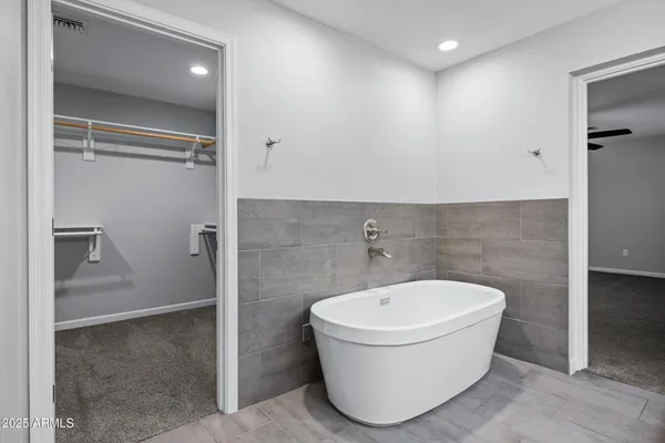 a bathroom with a granite countertop sink mirror and bathtub