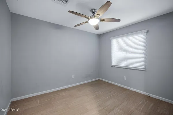 an empty room with a window and a fan