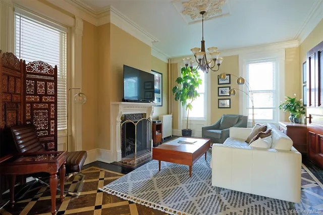 a living room with furniture a fireplace and a chandelier