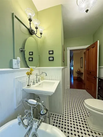 a view of a hallway with wooden floor and windows