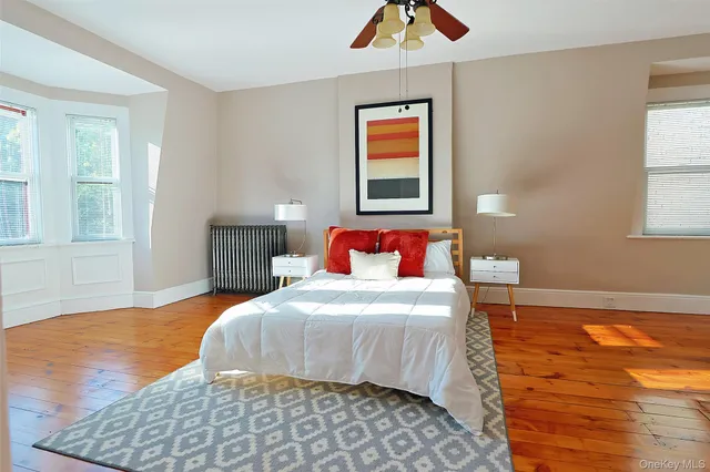 a bedroom with a bed a table and painting on the wall