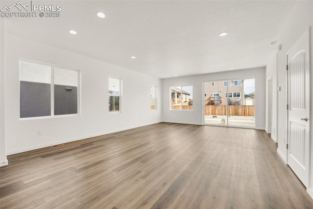 8156 Manor House Way Colorado Springs, CO 80908 - Photo 13 of 35 a view of an empty room with wooden floor and a window