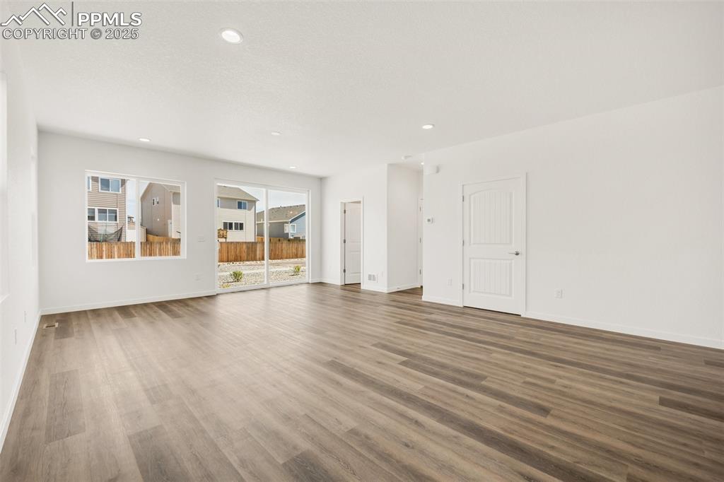 8156 Manor House Way Colorado Springs, CO 80908 - Photo 14 of 35 a view of an empty room with wooden floor and windows
