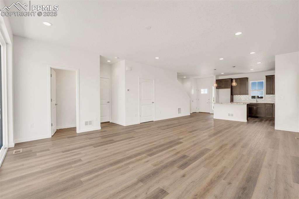 8156 Manor House Way Colorado Springs, CO 80908 - Photo 15 of 35 a view of kitchen and empty room with wooden floor