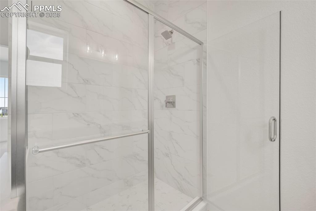 8156 Manor House Way Colorado Springs, CO 80908 - Photo 34 of 35 a bathroom with a glass shower door