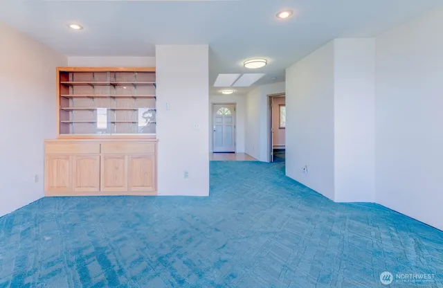 an empty room with cabinet and mirrors