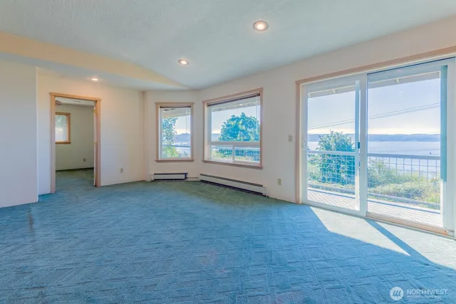 an empty room with windows and view of lake