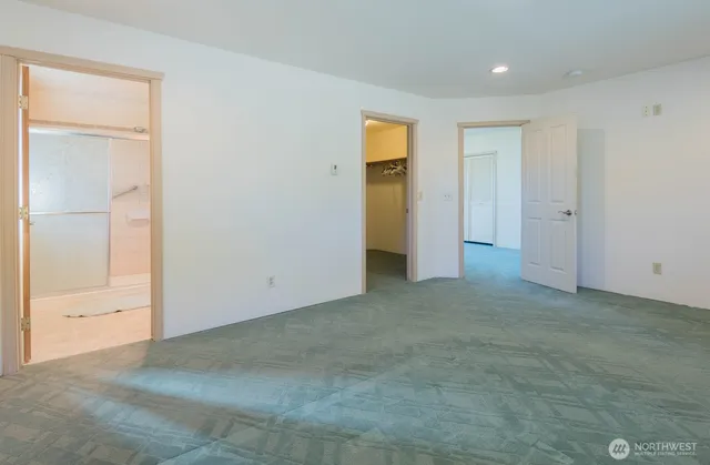 an empty room with closet and a bathroom