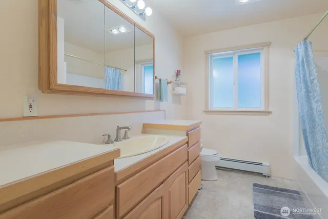 a bathroom with a sink a toilet and a mirror