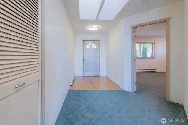 a view of a hallway with wooden floor and closet