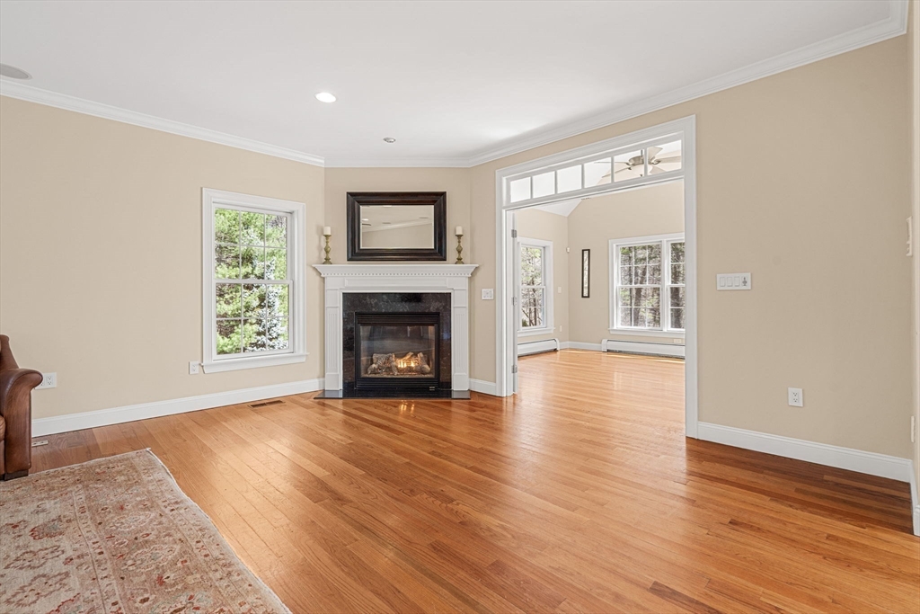 10 Sawyer Lane Middleton, MA 01949 - Photo 25 of 46 a view of a livingroom with wooden floor and a fireplace