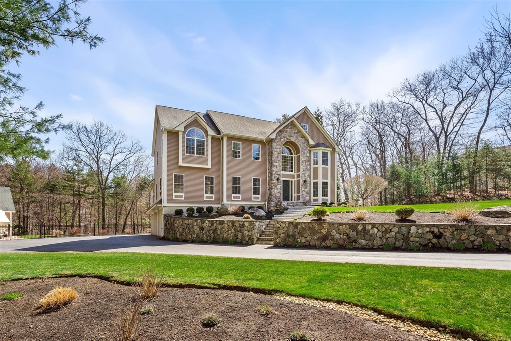 10 Sawyer Lane Middleton, MA 01949 - Photo 3 of 46 a front view of a house with a garden and trees