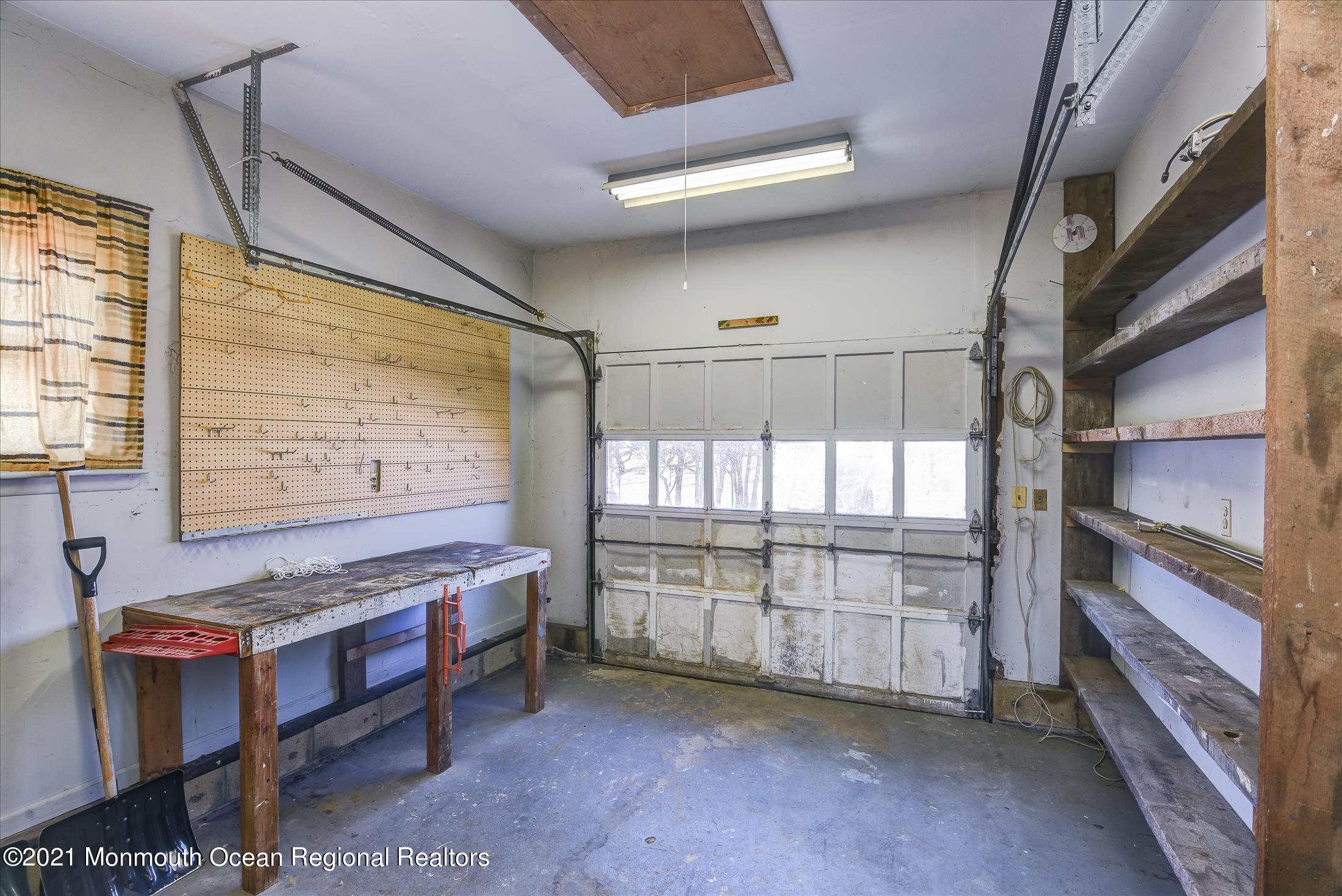 56 Burnt Tavern Road Brick, NJ 08724 - Photo 26 of 27 1 car garage with shelving and work benc