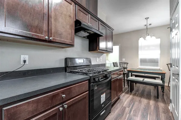 a kitchen with stainless steel appliances granite countertop a stove and a wooden floors