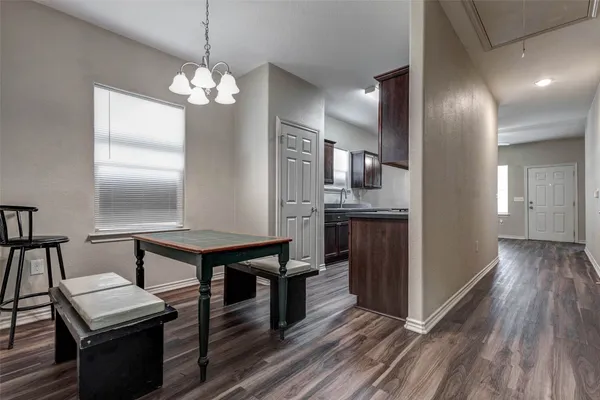 a kitchen with stainless steel appliances a dining table chairs and wooden floor