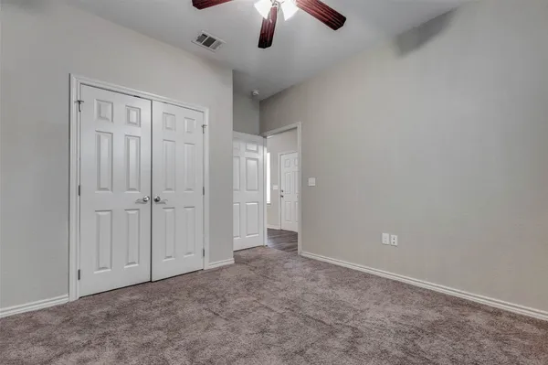 an empty room with chandelier fan