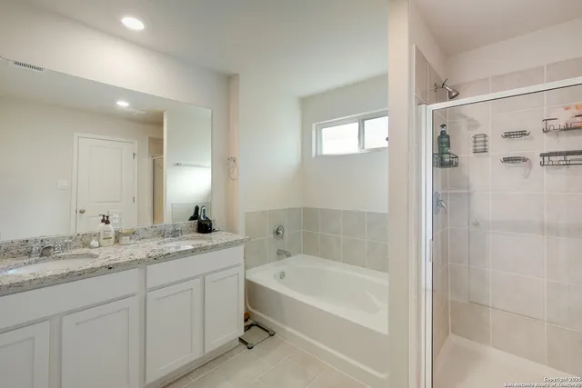 a bathroom with a granite countertop sink a mirror bathtub and shower