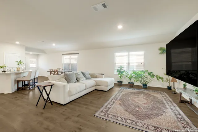 a living room with furniture windows and a flat screen tv