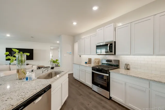 a kitchen with sink a microwave and cabinets