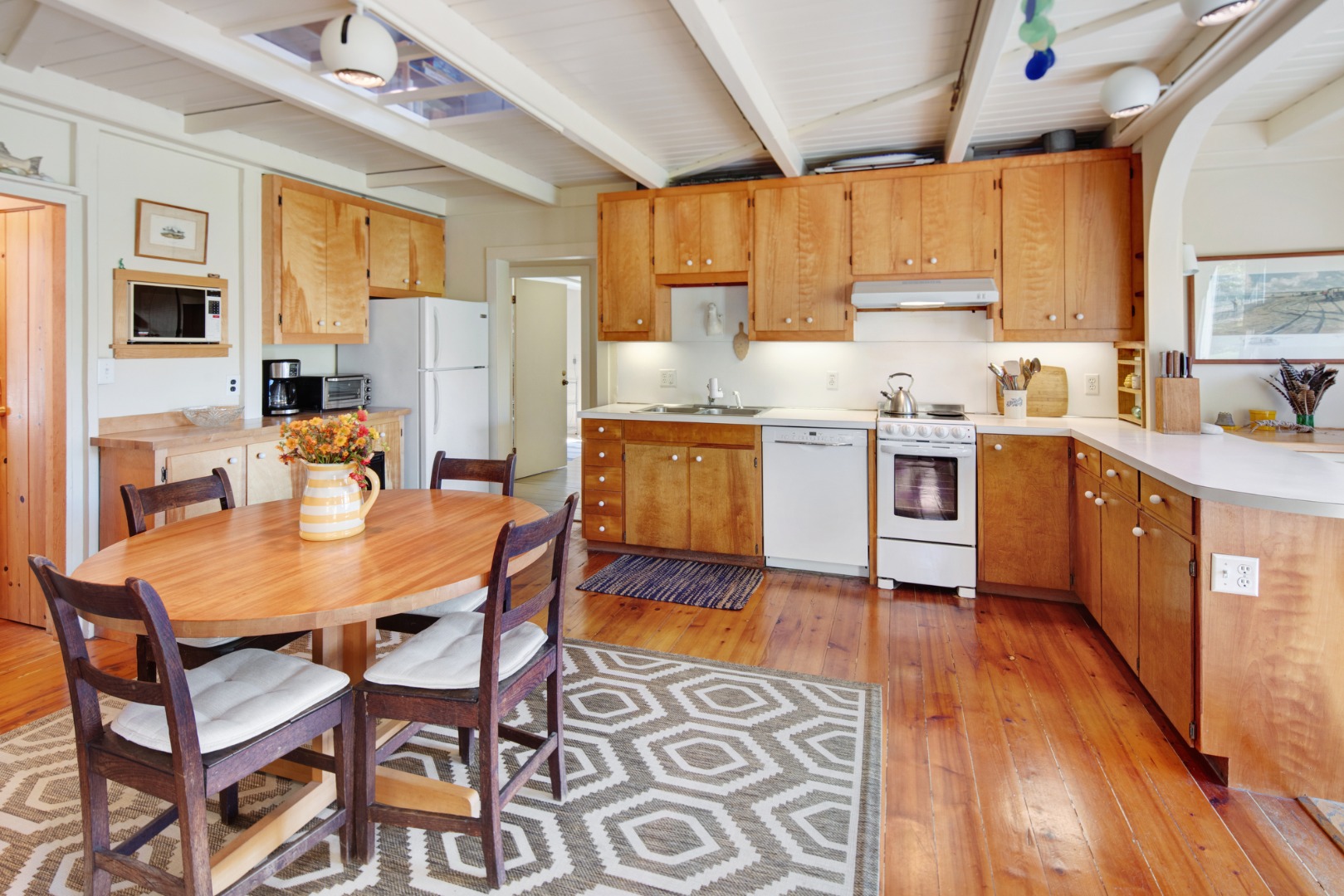 10 Abel's Neck Road Chilmark, MA 02535 - Photo 3 of 20 a kitchen with stainless steel appliances granite countertop wooden cabinets a dining table and chairs