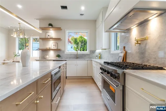 a kitchen with stainless steel appliances granite countertop a sink and a stove