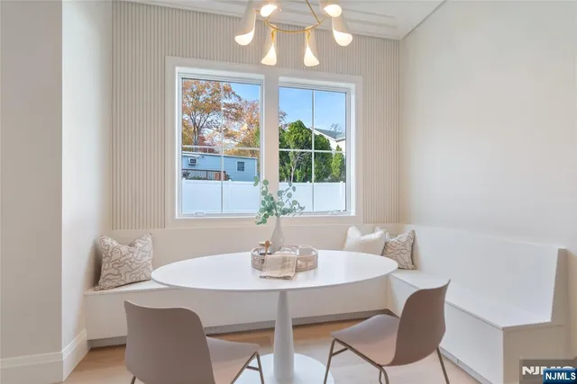 a dining room with furniture a large window and wooden floor