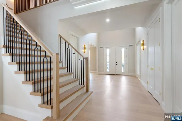 a view of a hallway with wooden floor and stairs