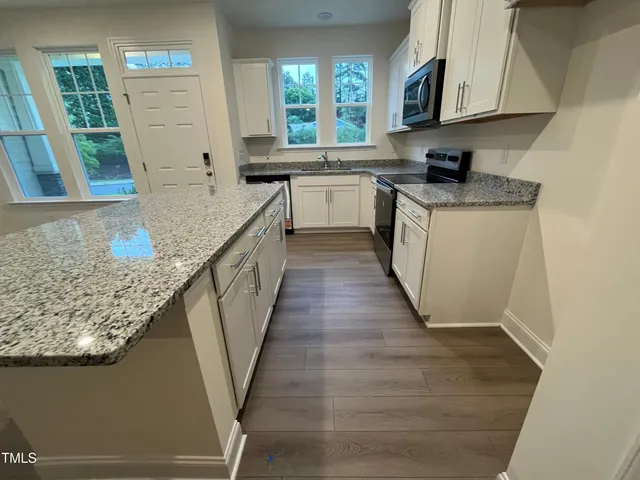 a view of a kitchen with wooden floor and a sink