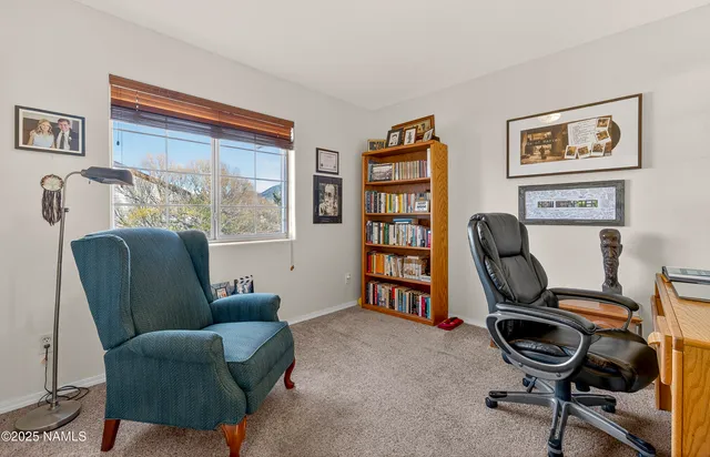 a view of a workspace with furniture and a window